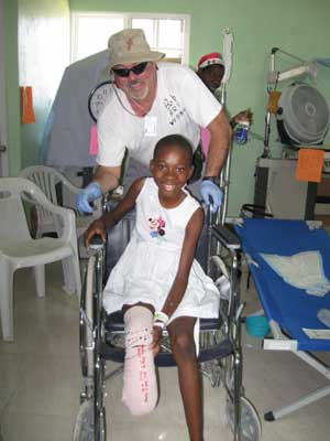 Bob Stafford pushes a young patient through the compound's health facility